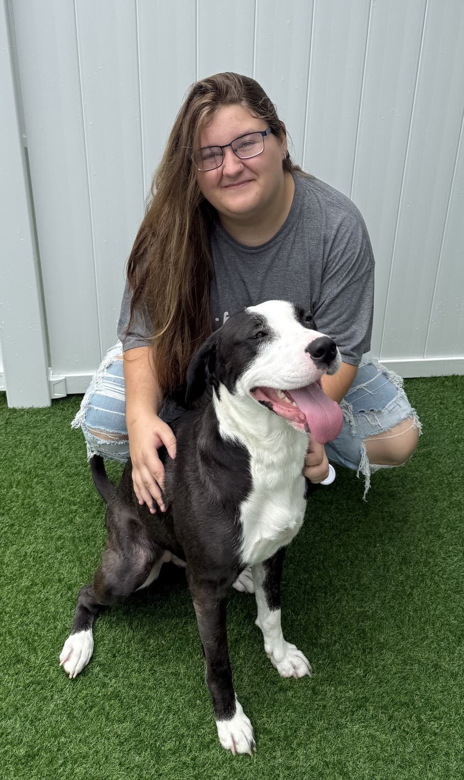 Bridgette, lead groomer at Doggie Den Inn, with a happy dog